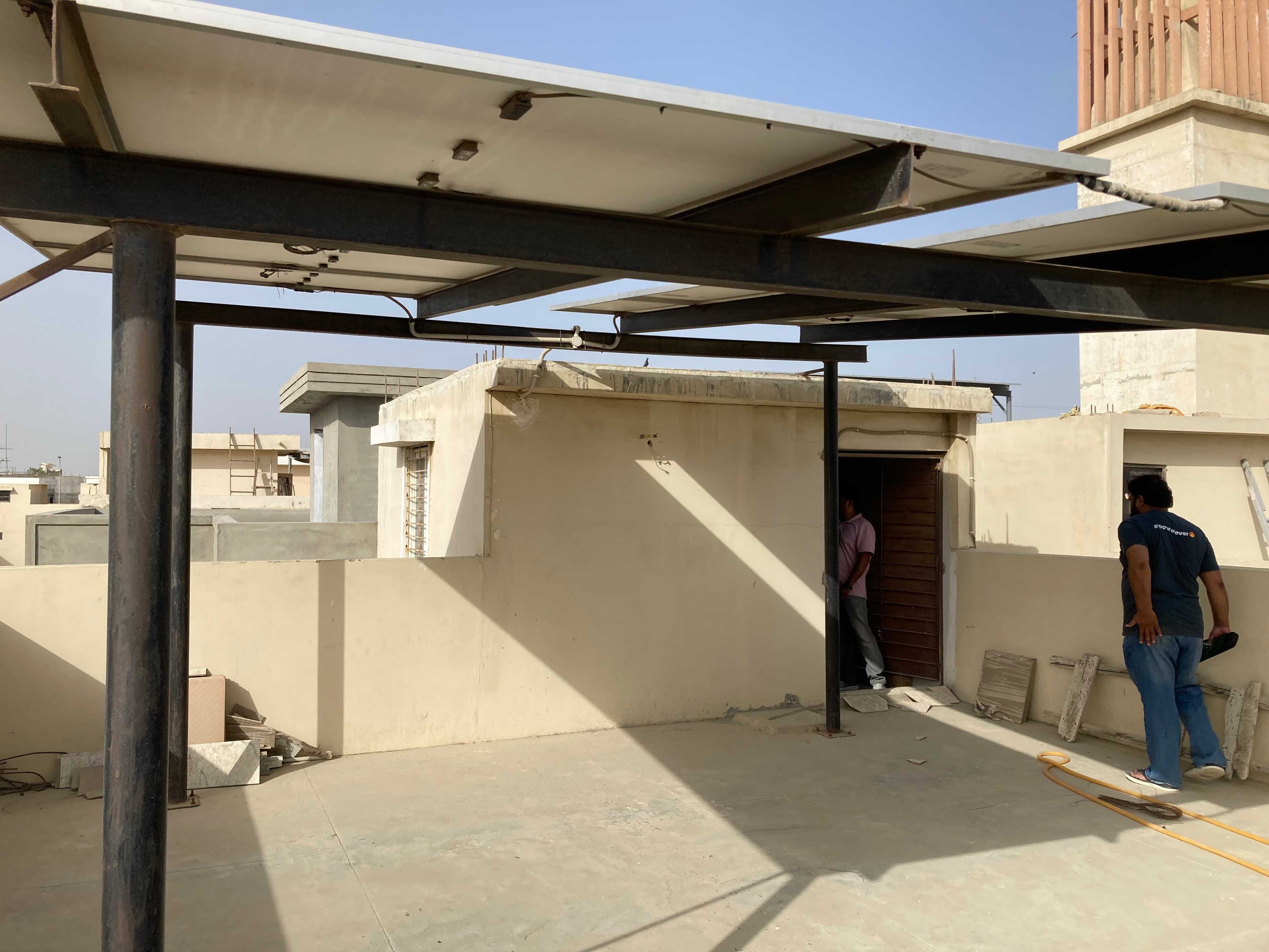 Solar canopy structure under installation on a Karachi rooftop.