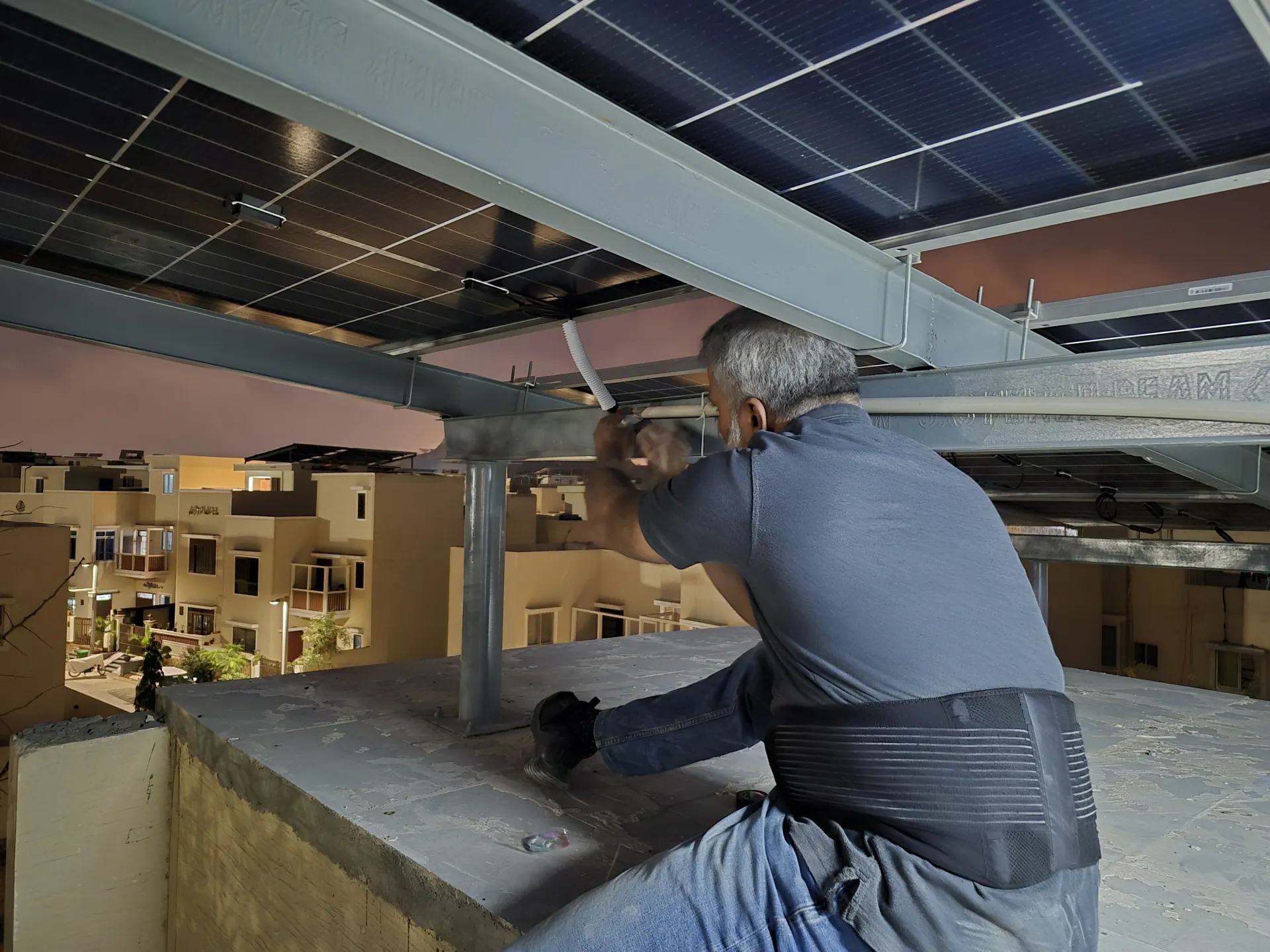 Technician wiring rooftop solar panels during an active Karachi installation.
