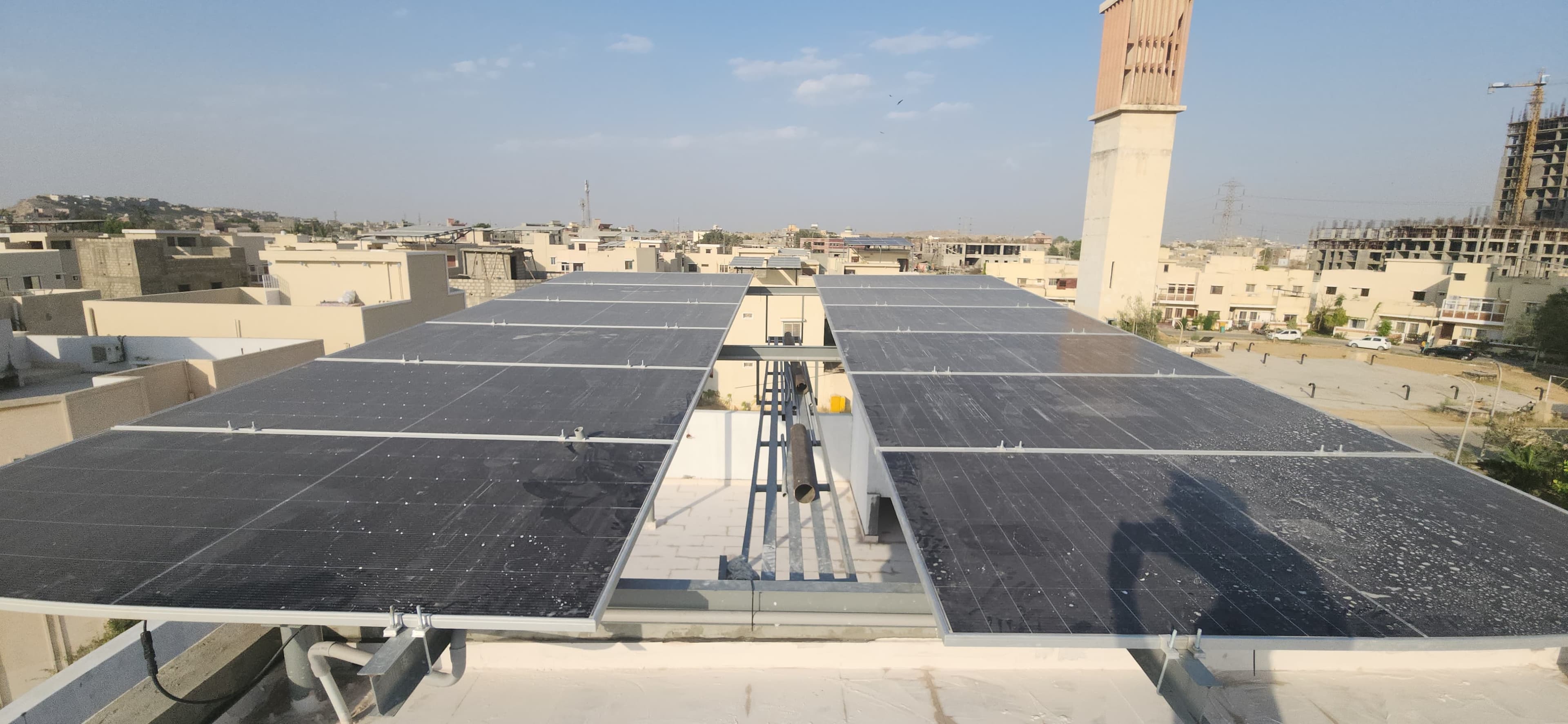Large finished rooftop solar installation spanning multiple adjoining roofs in Karachi.